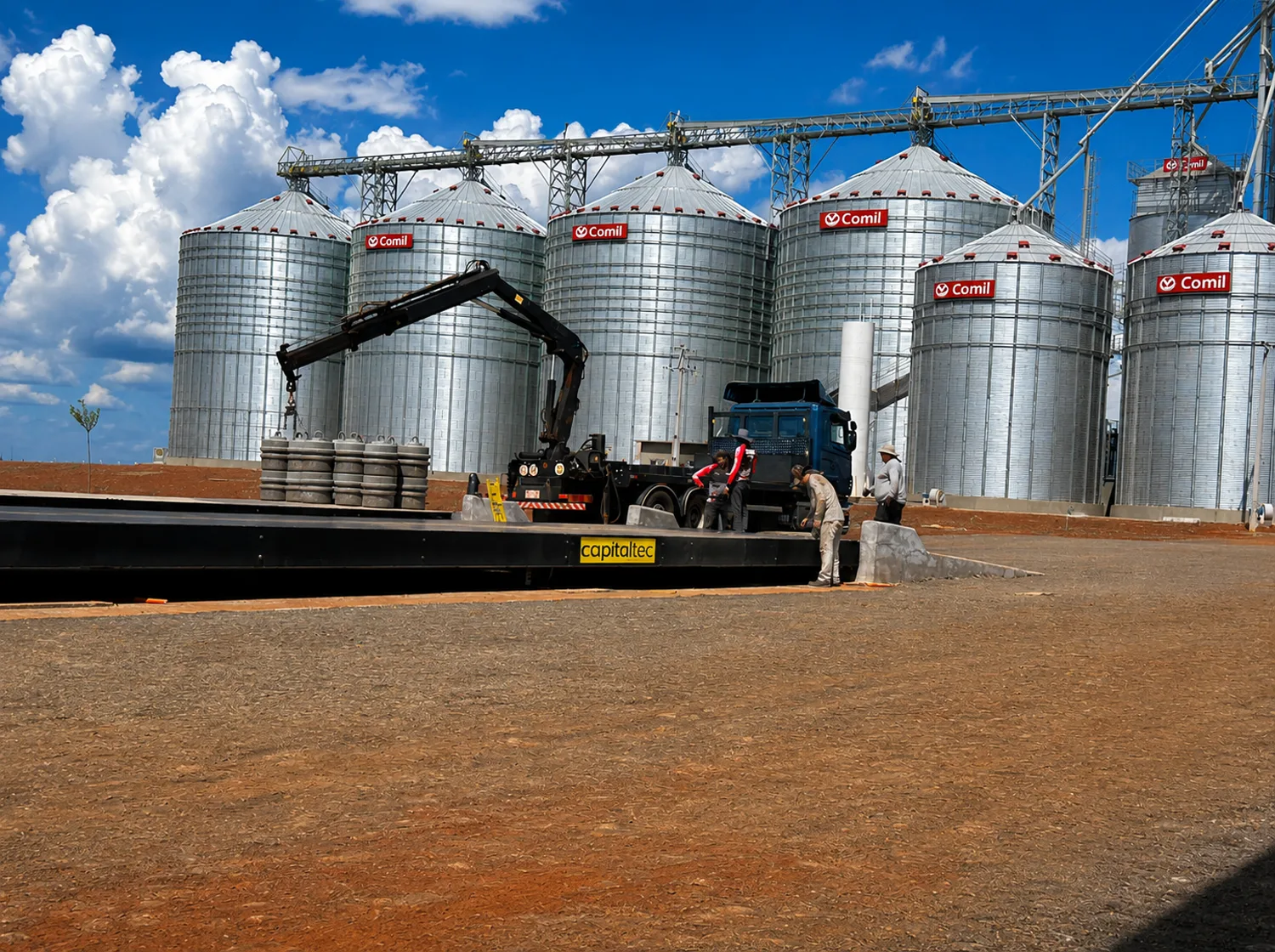 Equipo Capitaltec instalando una báscula frente a silos de granos